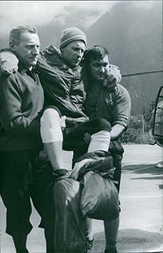 İki kişi tarafından taşınan yaralı bir adamın vintage fotoğrafı.